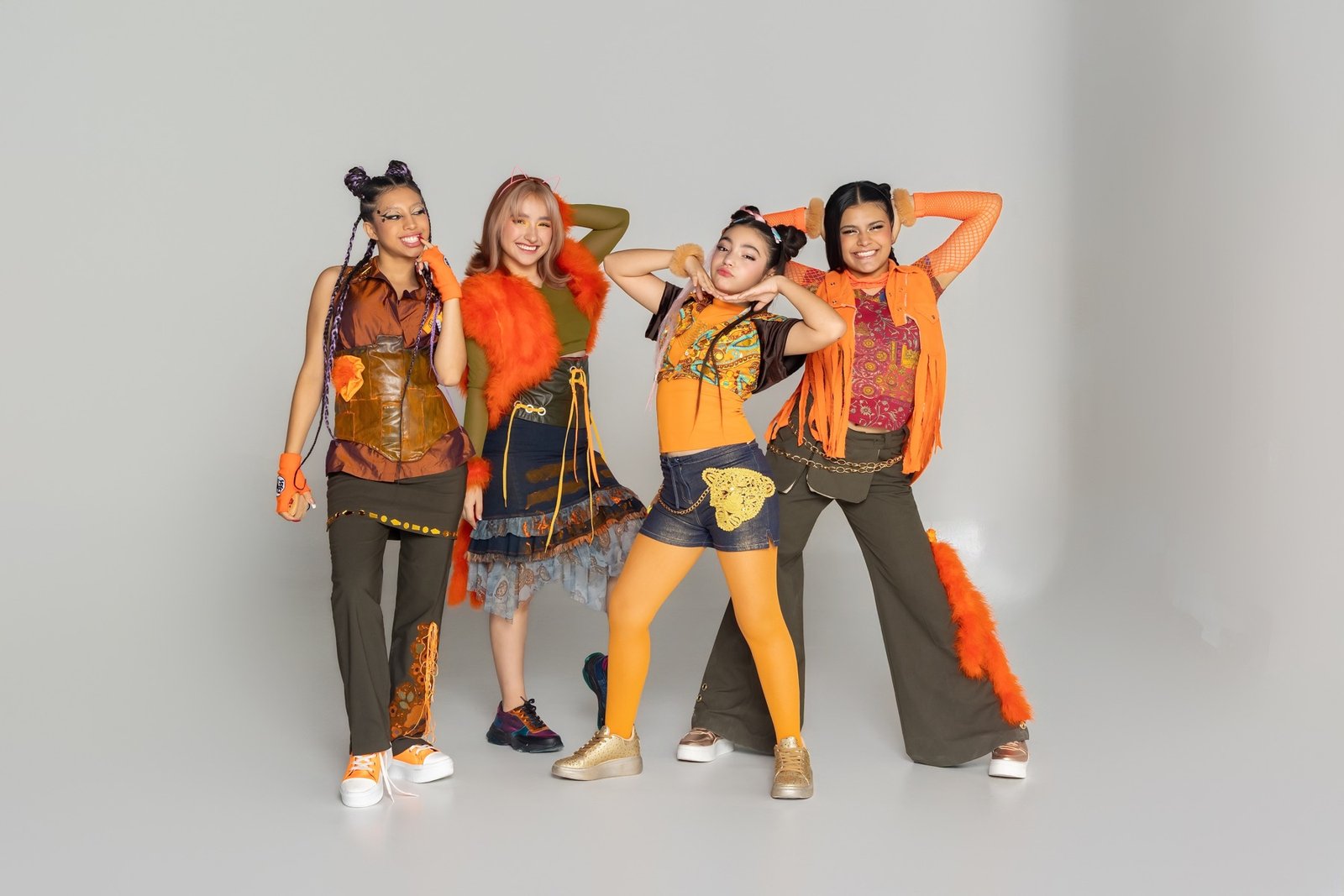 Las integrantes de JEANS NG posando juntas con vestuario naranja